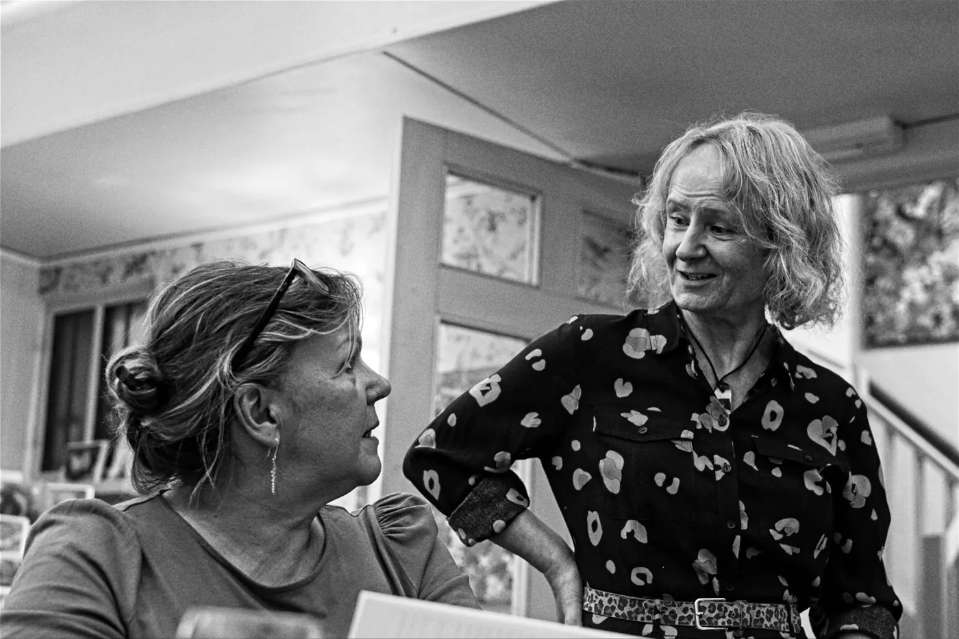 Black and white photograph of two women chatting at the exhibition