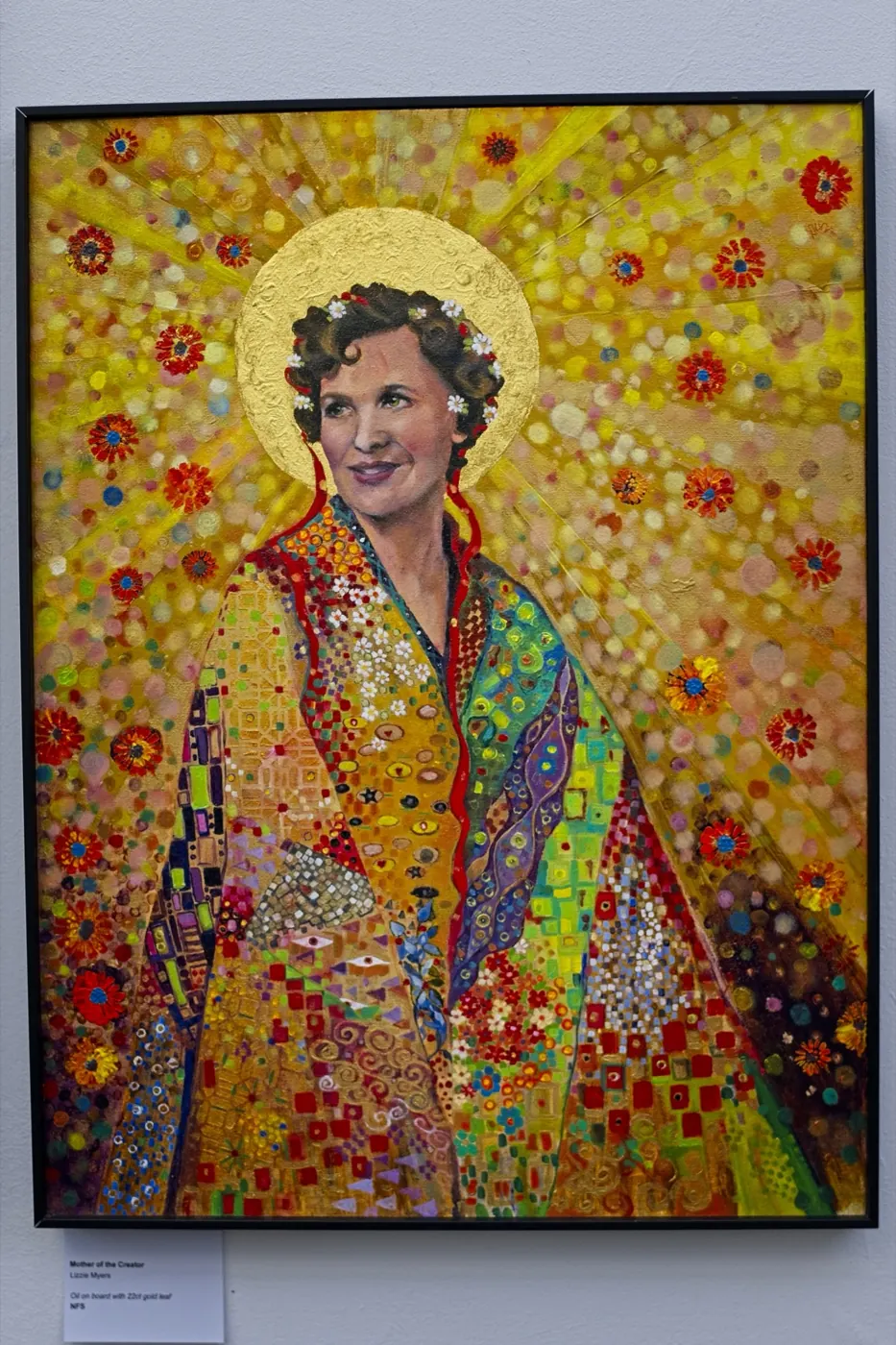 Mother of the Creator, a golden mosaic-like portrait, on a white wall